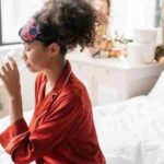 Woman in red pajamas drinking water, enhancing morning wellness rituals., tags: einfache die tag und - pexel
