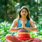 Serene woman practicing yoga in a lush green garden, focusing on mindfulness and relaxation., tags: happiness begleitet frauen - pexel