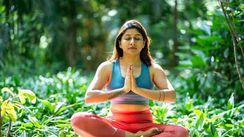 Serene woman practicing yoga in a lush green garden, focusing on mindfulness and relaxation., tags: happiness begleitet frauen - pexel